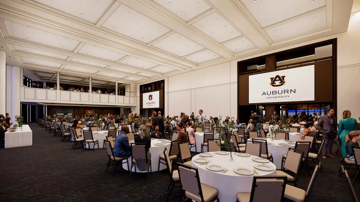 Rendering of the Ballroom set for a formal banquet with round tables, large projection screens, and Auburn branding