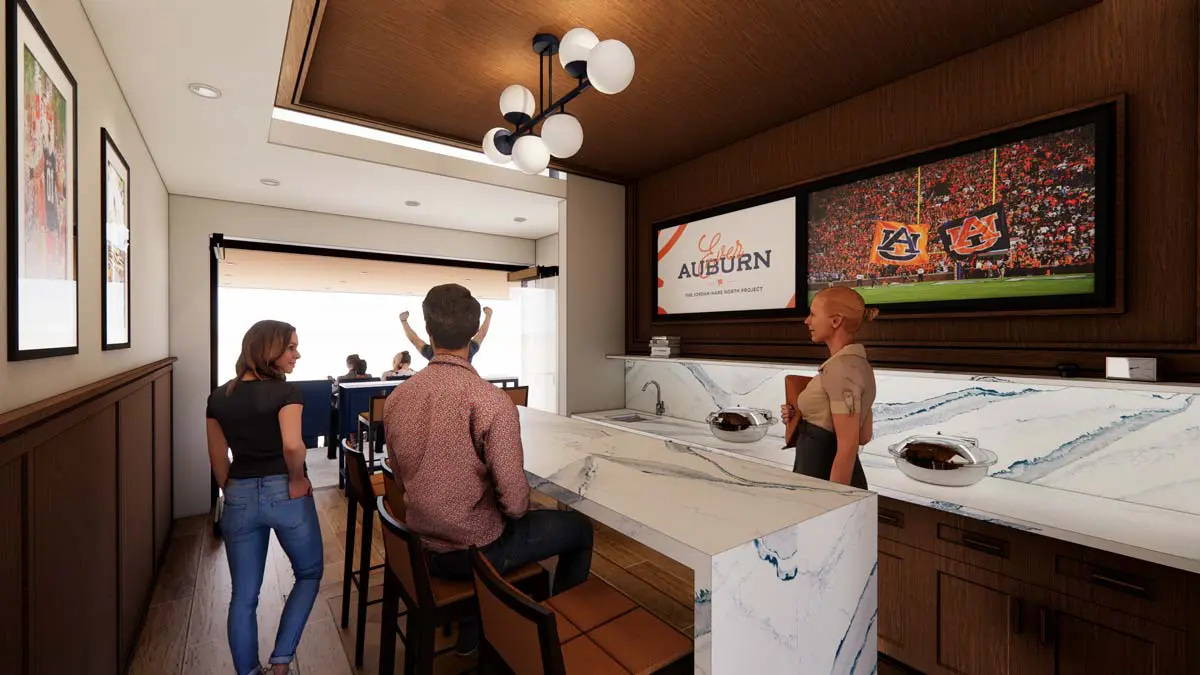 Rendering of a Heisman Suite with marble counter, bar seating, and wall-mounted screen with field views
